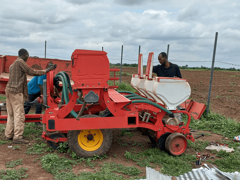 An iMTS crew setting up a four-row precision planter at the field edge